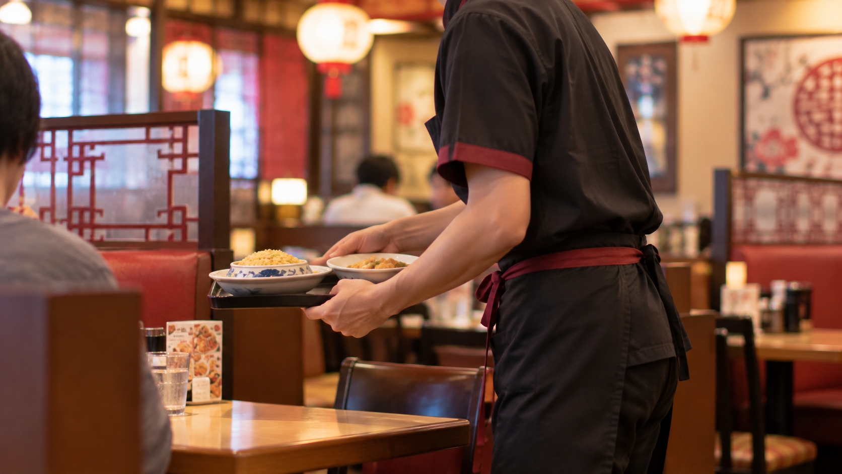 バーミヤンで炒飯と点心を運ぶホールスタッフの店内風景